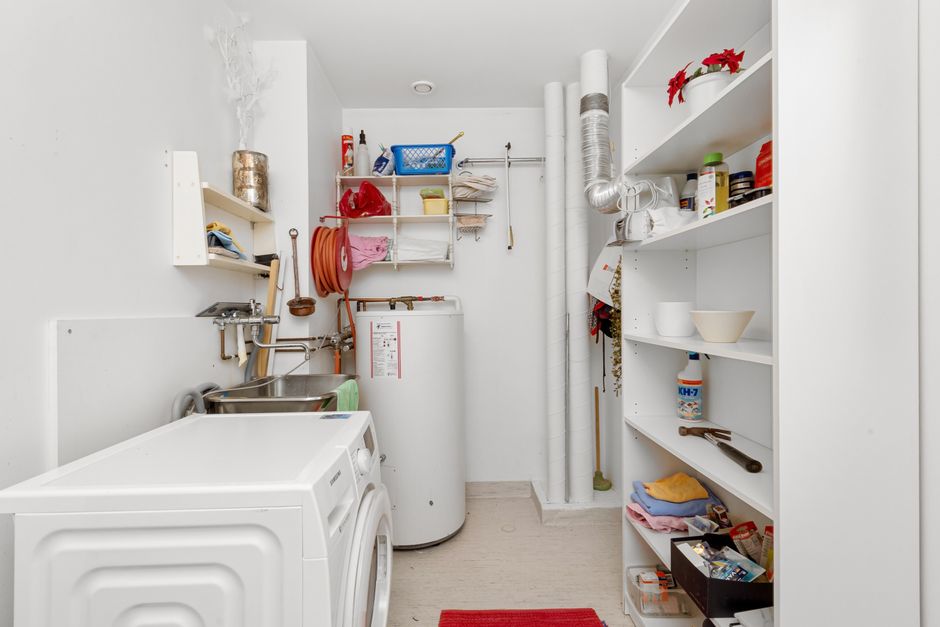 A clean, organized apartment laundry room with washers and dryers
