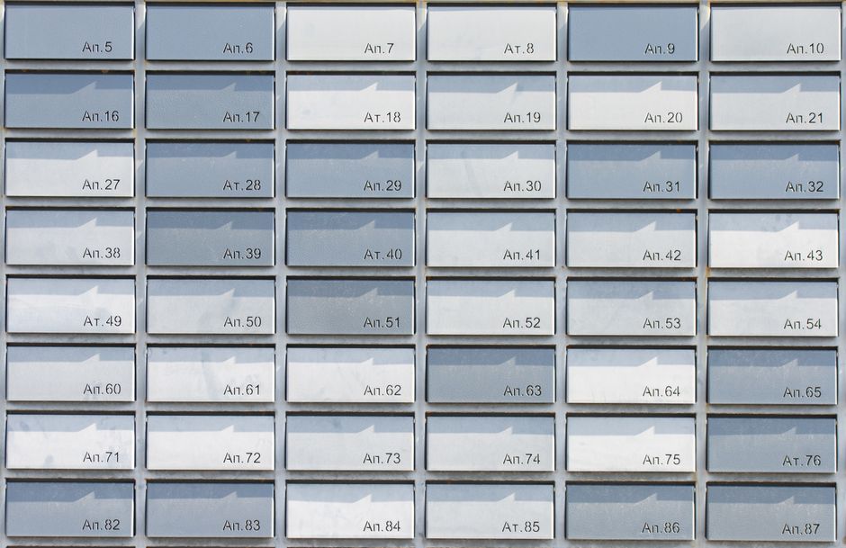 A wall of metal resident mailboxes in an apartment building lobby