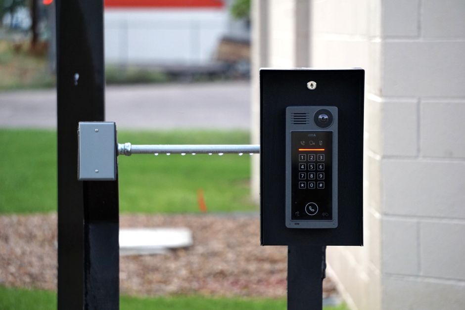 A video doorbell camera mounted on the wall beside an apartment front door