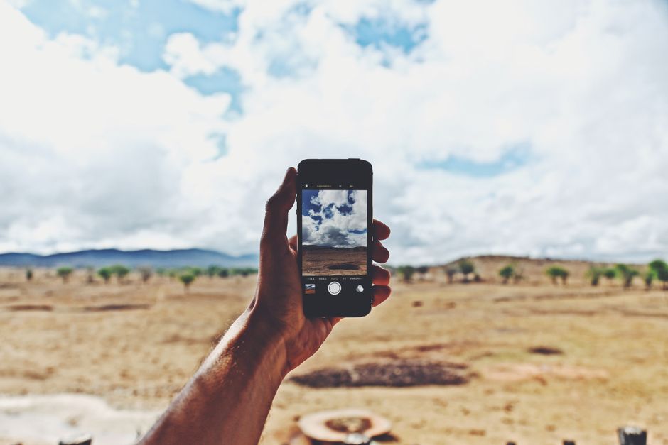 A person using a smartphone to photograph an empty apartment room during a move-in walkthrough