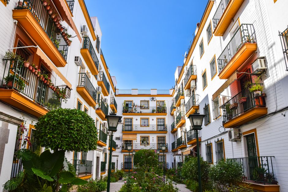 A shared apartment courtyard patio with outdoor chairs and small tables arranged for residents