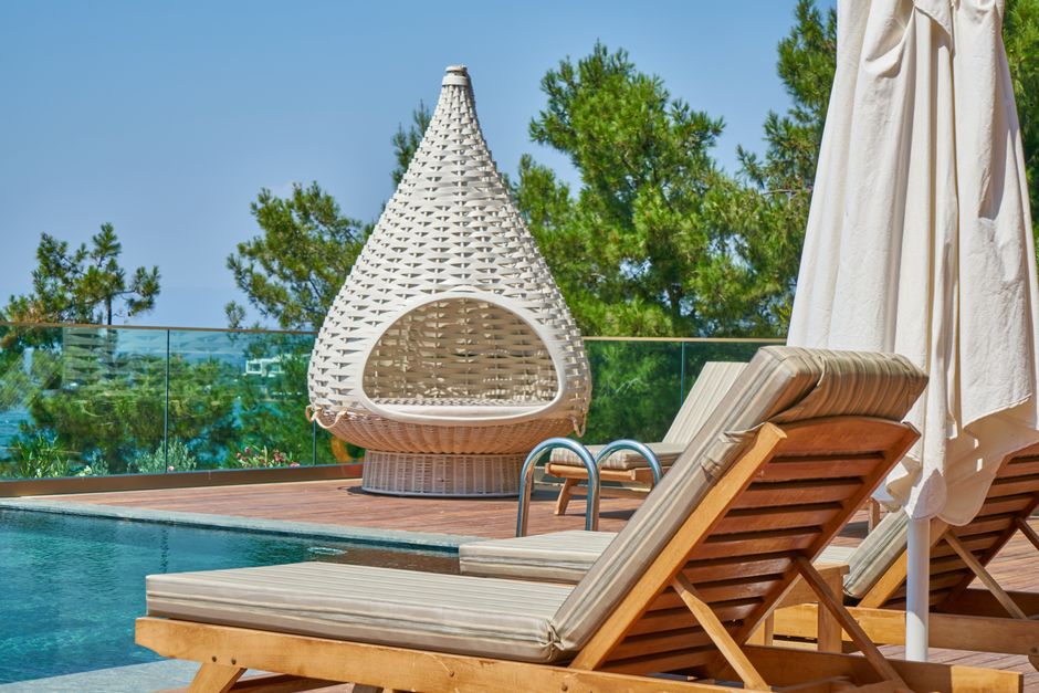 A row of empty lounge chairs lined up along an apartment pool deck