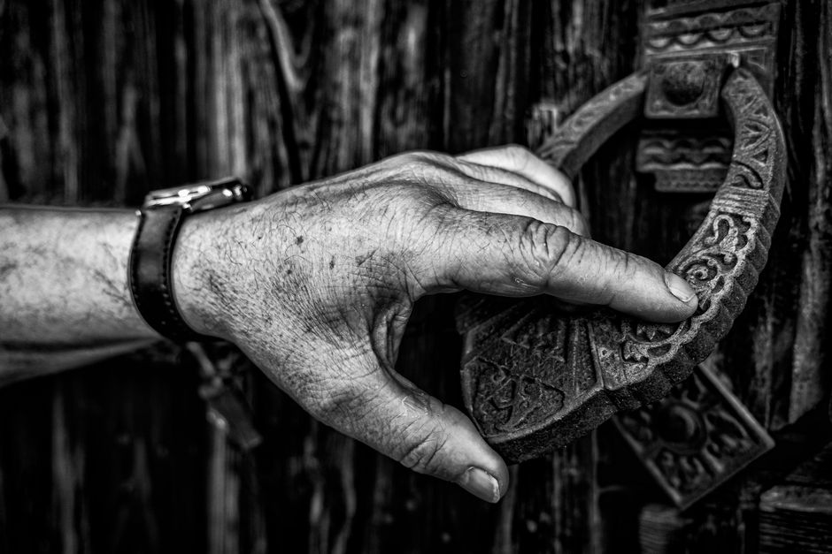 A person's hand knocking on an apartment unit door