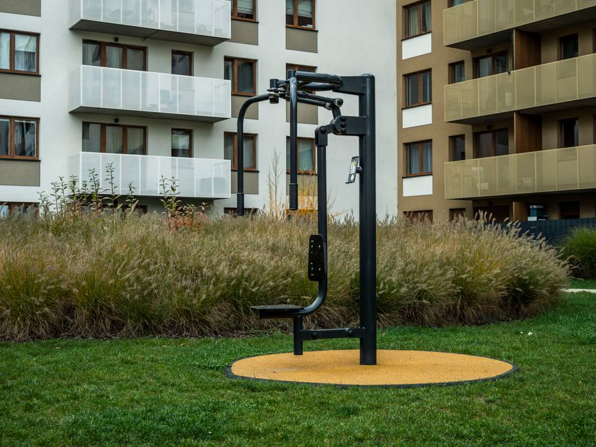 A compact in-building apartment gym with a treadmill and a couple of cardio machines against a mirrored wall