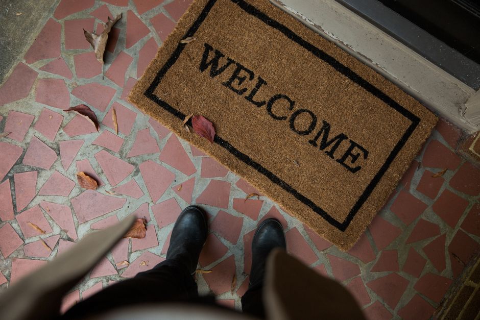 A welcome doormat placed outside an apartment door, a small cue that the new resident has settled in.