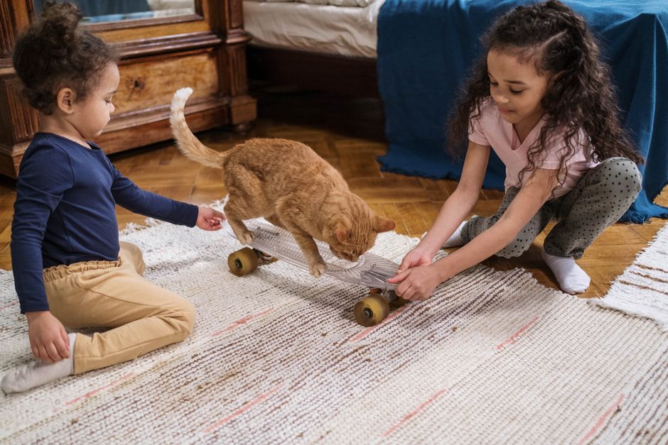 Young children playing on a soft rug in an apartment living room, the kind of everyday activity that carries as impact noise