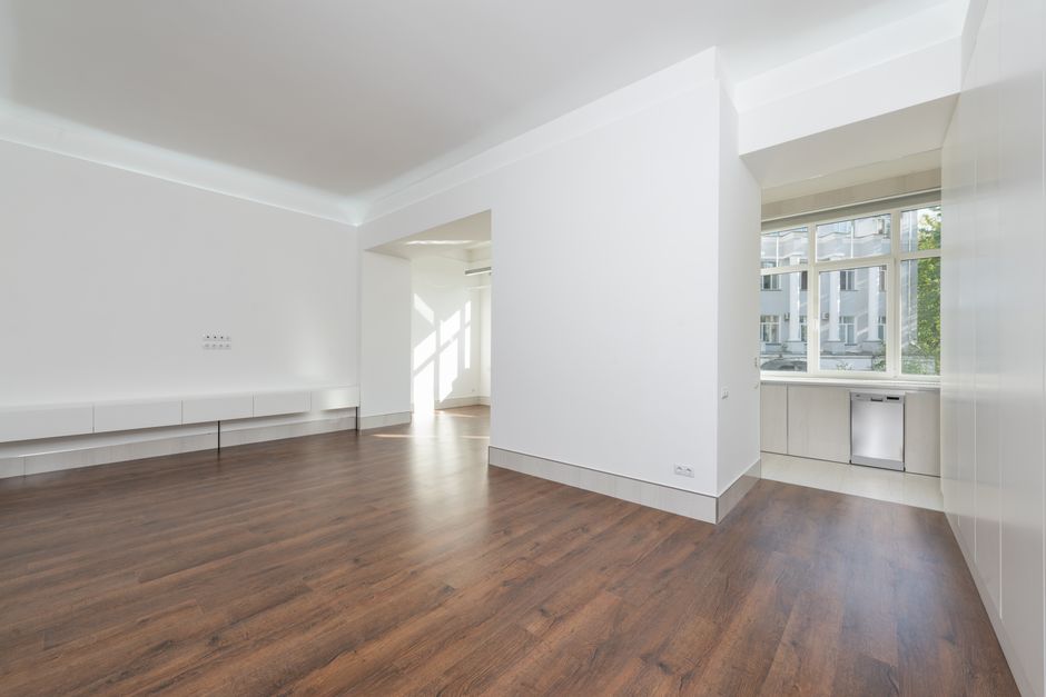 An empty apartment kitchen with bare countertops, cabinets, and appliances ready to be documented at move-in