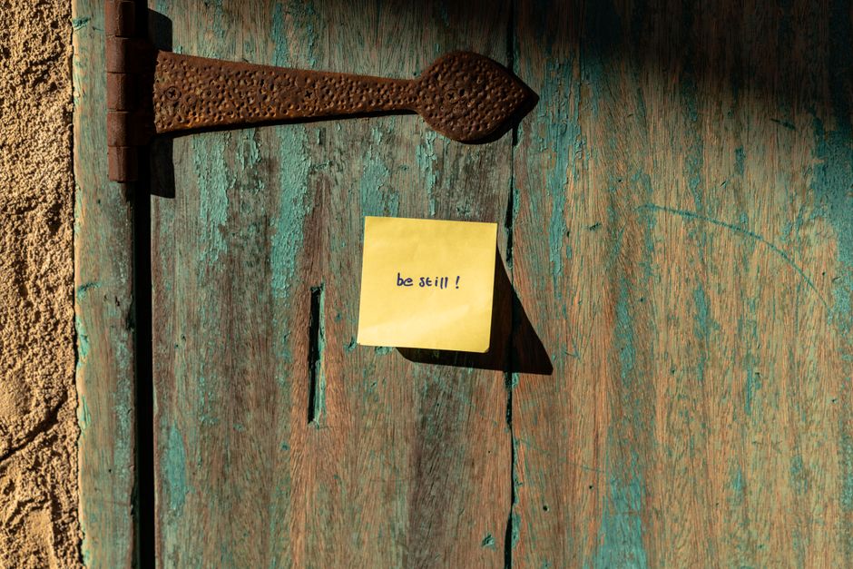 A folded paper note slipped underneath a closed apartment door.