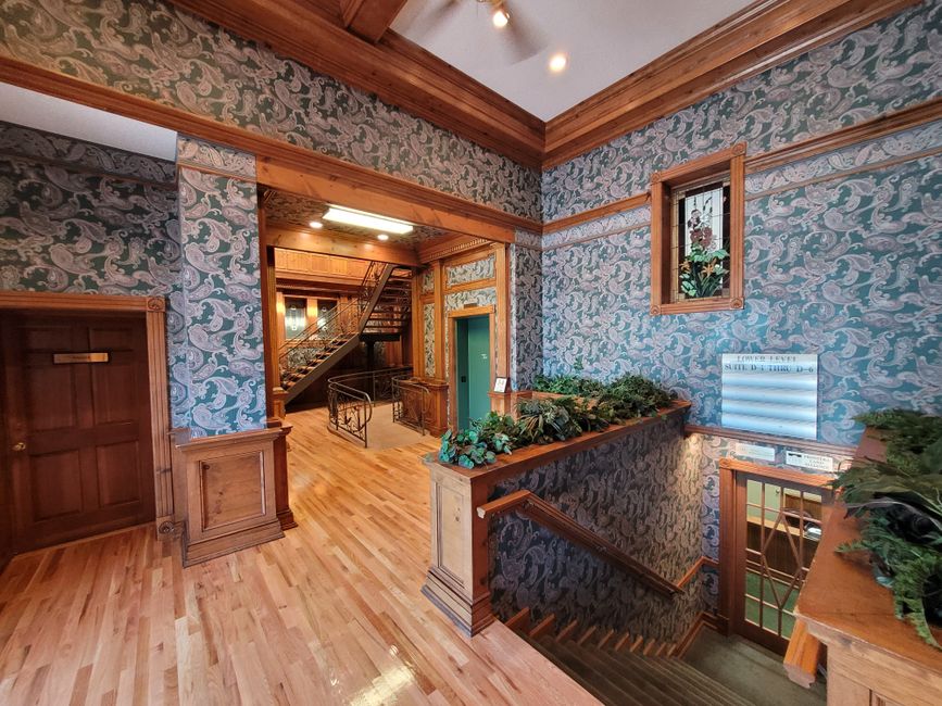 A quiet residential building lobby where residents pass through and daily foot-traffic patterns become familiar