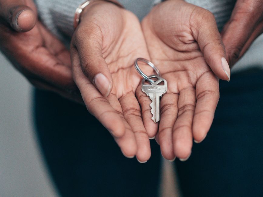 A person handing apartment keys to a subletter during the unit handoff