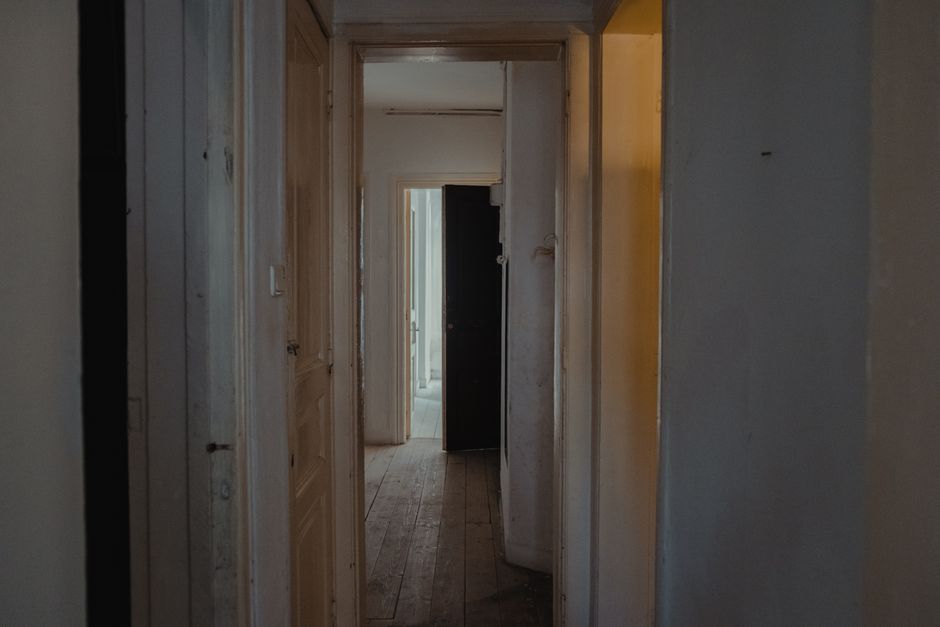 A quiet, empty apartment hallway lined with closed unit doors.