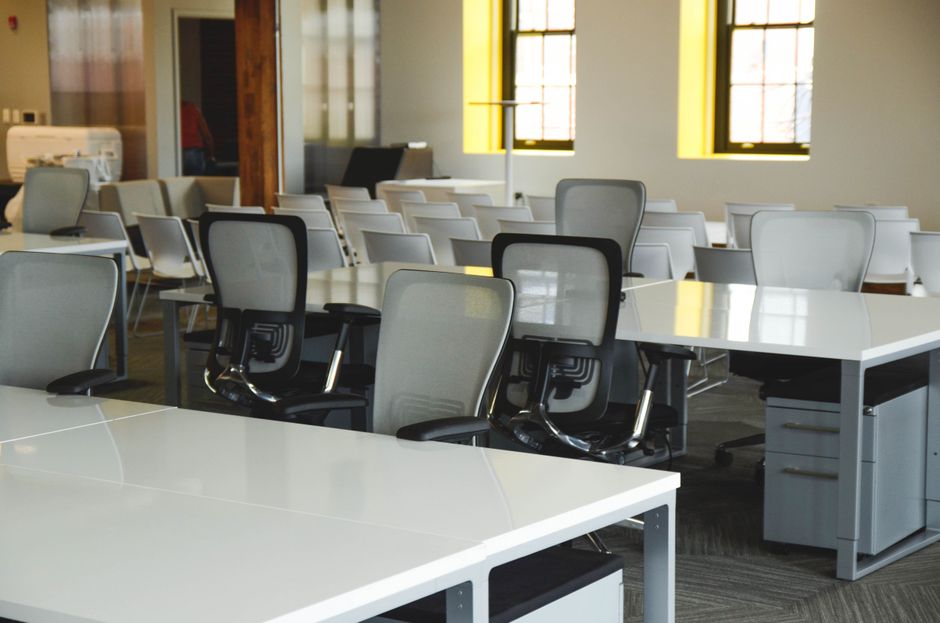 Shared co-working desks with chairs and monitors in a building amenity workspace