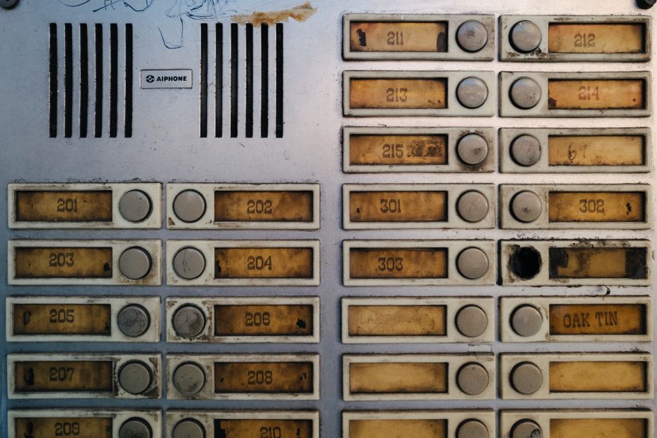 An apartment building entry intercom and buzzer panel used to let guests into the lobby