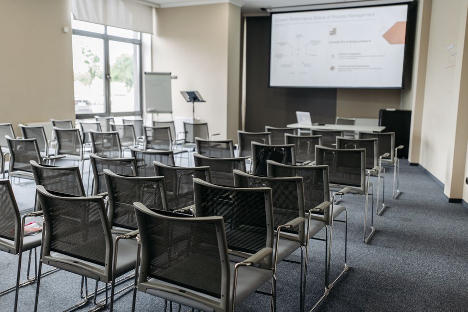 Rows of folding chairs arranged in an apartment community room set up for a residents' building meeting