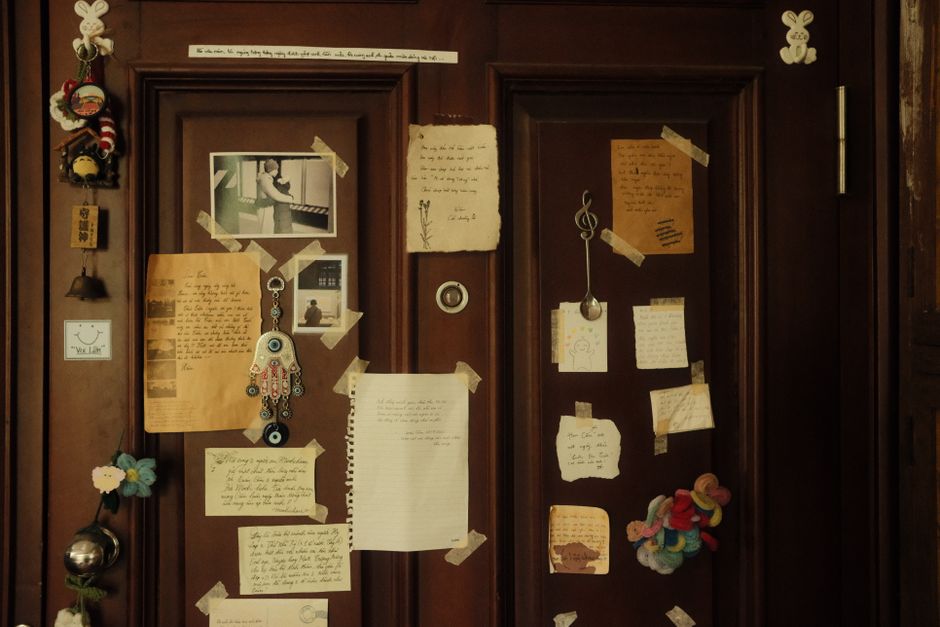 A handwritten note taped to an apartment door in a hallway