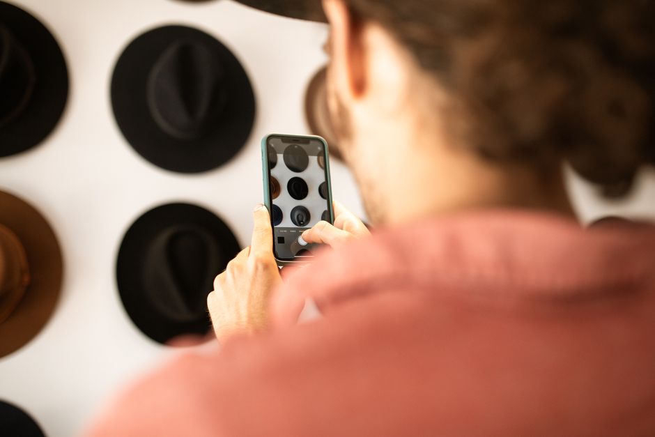 A person using a smartphone to photograph the wall and floor of an empty apartment to document its condition at move-in