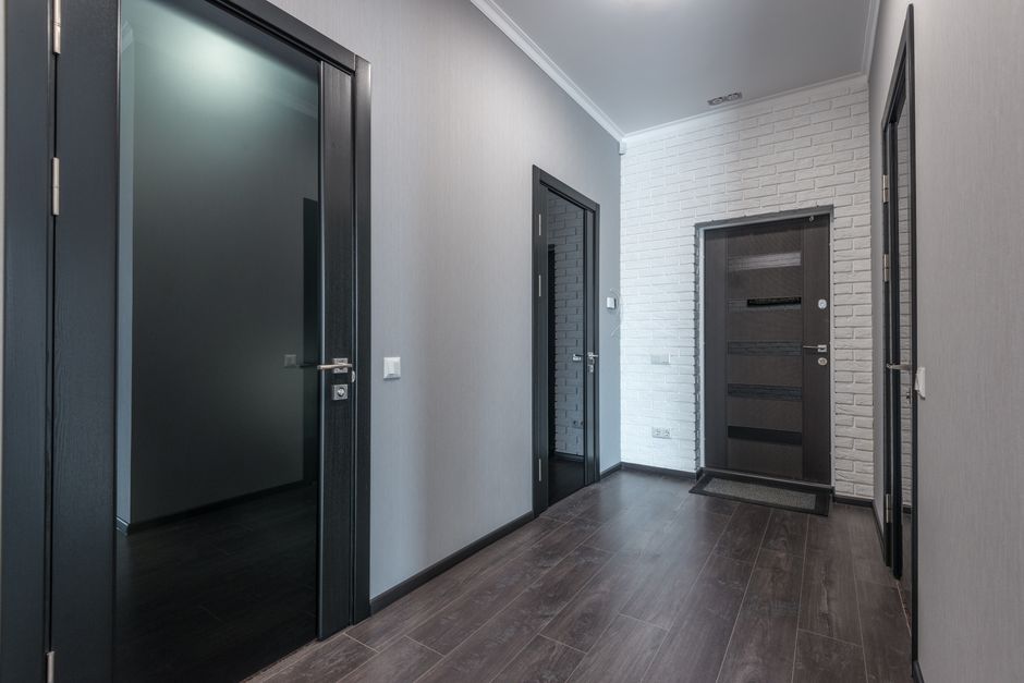 A carpeted apartment building hallway lined with numbered unit doors along one floor