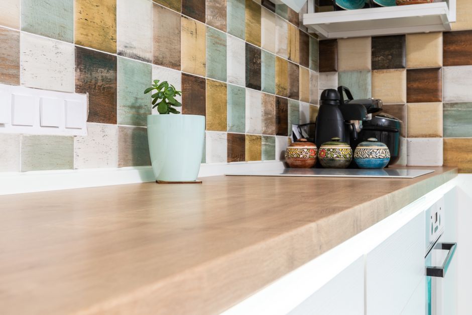 Someone wiping down kitchen counters and appliances during an end-of-tenancy deep clean before the move-out walkthrough