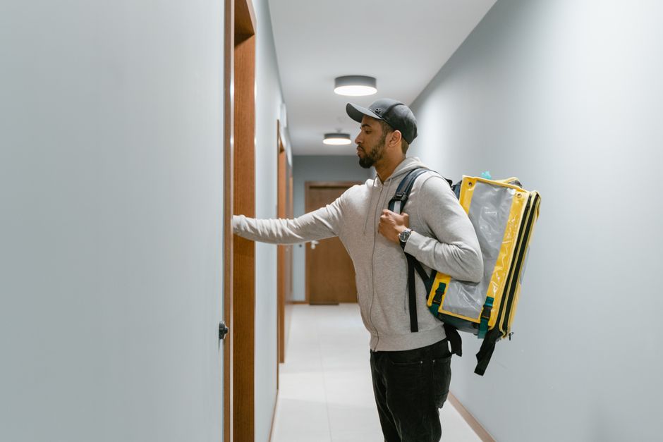 A person knocking on a neighbor's apartment door to apologize face to face.