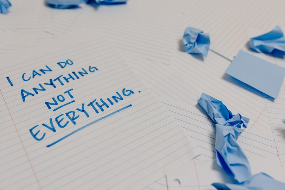 A short handwritten apology note on paper ready to slip under a neighbor's door.
