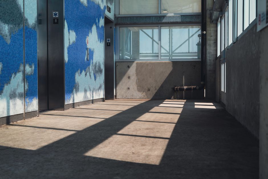 The interior of an apartment building elevator with metal walls and a closing door