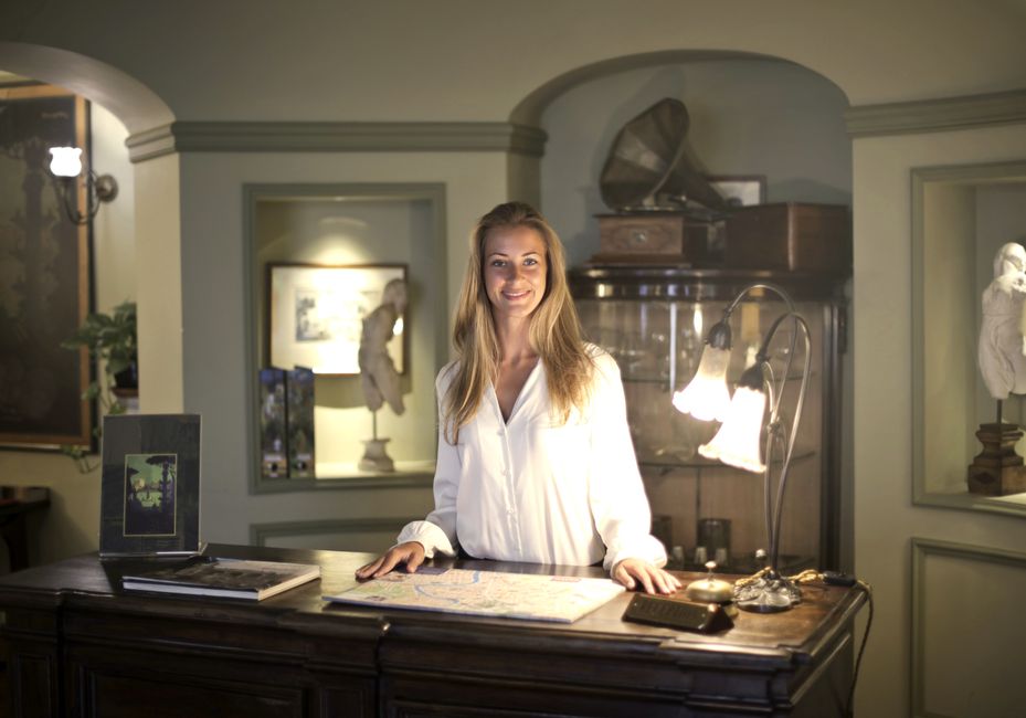 A staff member at the front desk of a residential apartment lobby