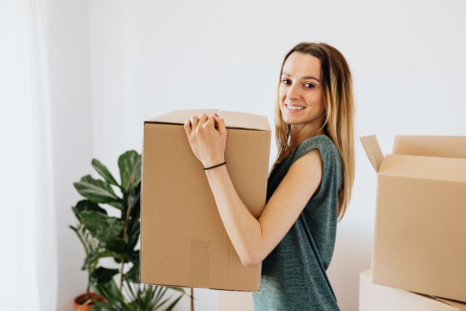 Stacked cardboard moving boxes in an empty apartment room, representing the option to move at lease end