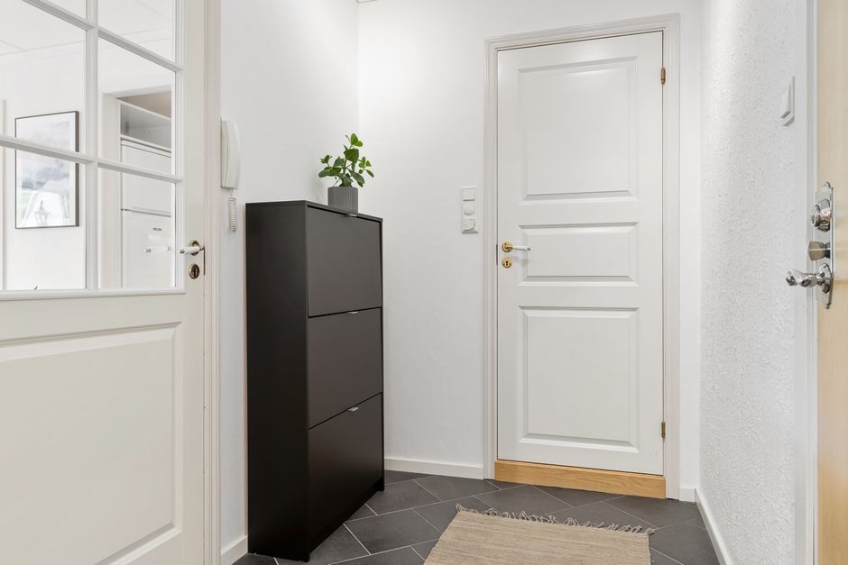 A quiet apartment building corridor lined with neighboring unit doors, where everyday neighbor disputes begin.
