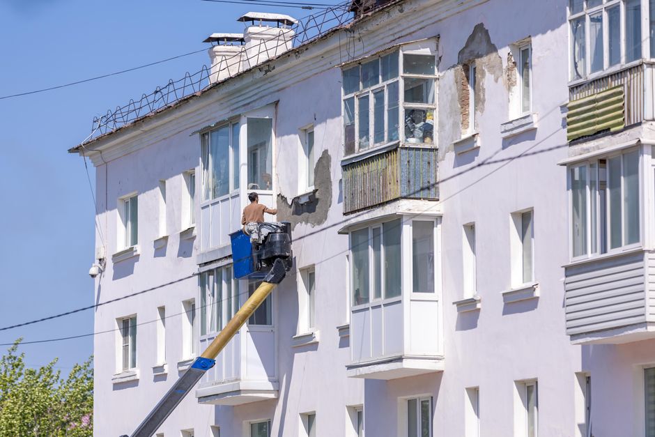 A maintenance worker inspecting an apartment fixture during a diagnostic repair visit.