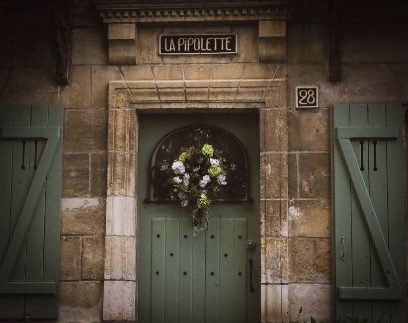 A decorative wreath hanging on a door in a shared apartment hallway, the kind of small shared-space object that can quietly b