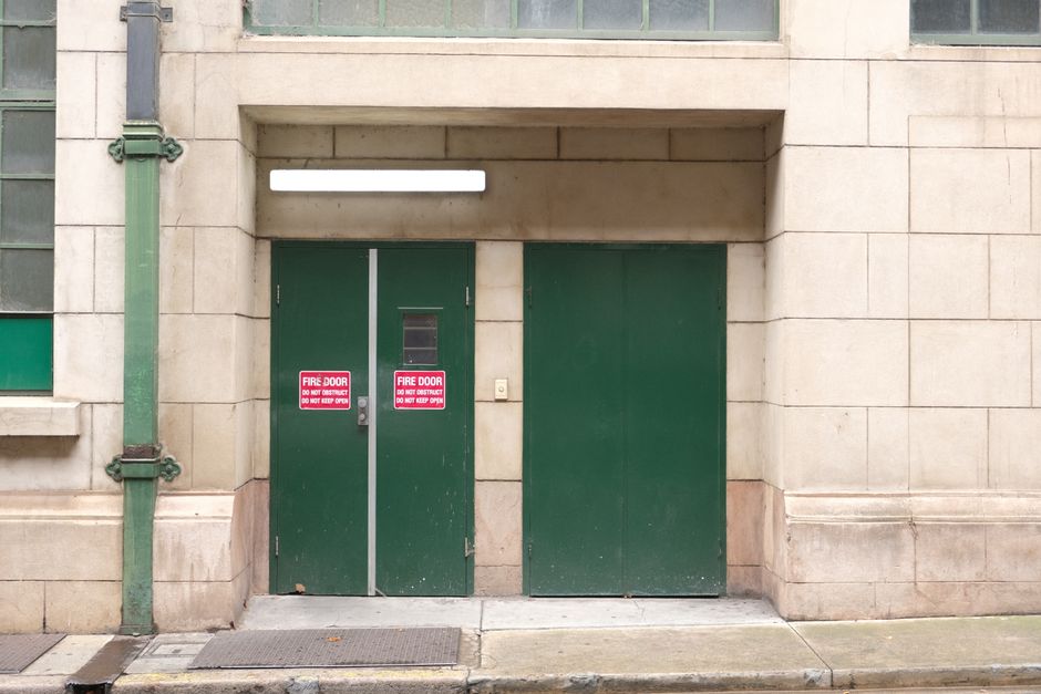 A closed fire-rated stairwell door with a push bar, the kind meant to stay shut on every floor