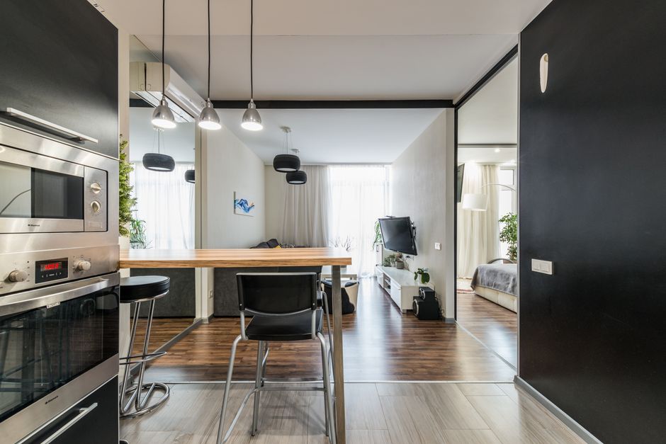 A compact studio apartment interior with a small tidy living area and natural light
