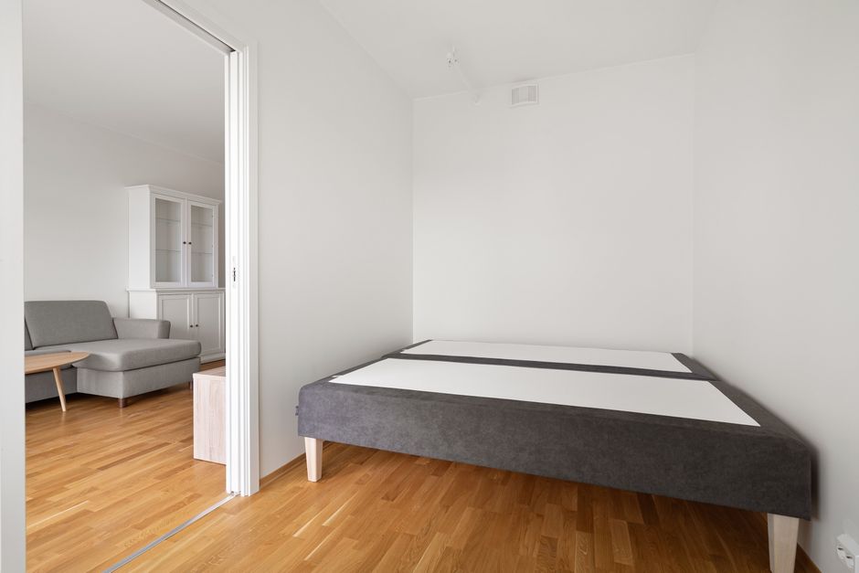 A plain interior wall in an apartment bedroom, the kind of shared wall that carries sound between neighboring units.