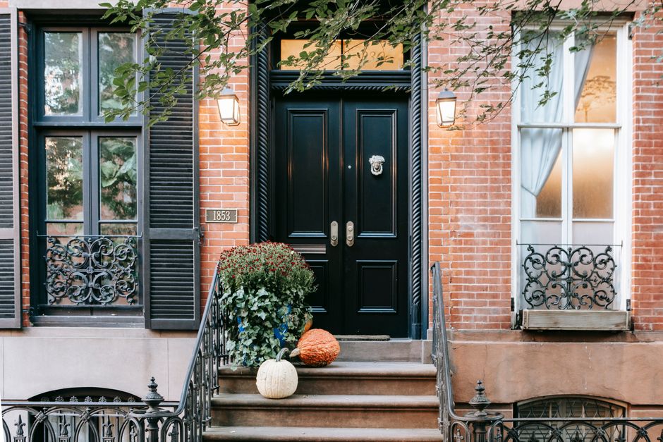 The front steps and stoop of an urban apartment building leading up to the entrance door