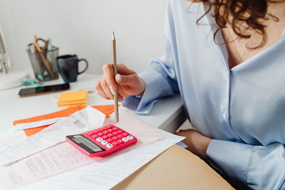 A calculator, bills, and a notepad used to work out the all-in cost of a rent increase