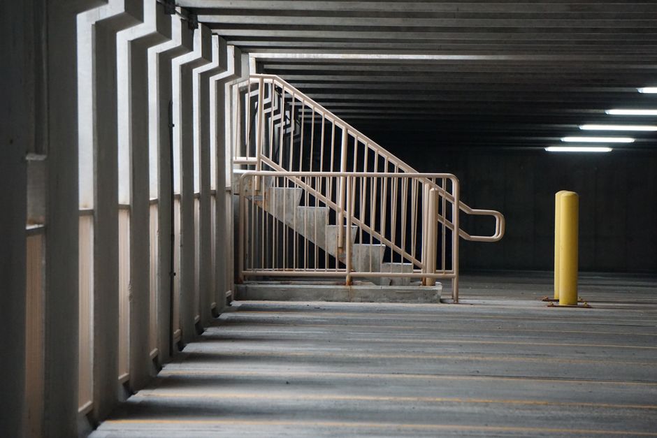 A dimly lit concrete parking garage stairwell where added lighting would improve safety