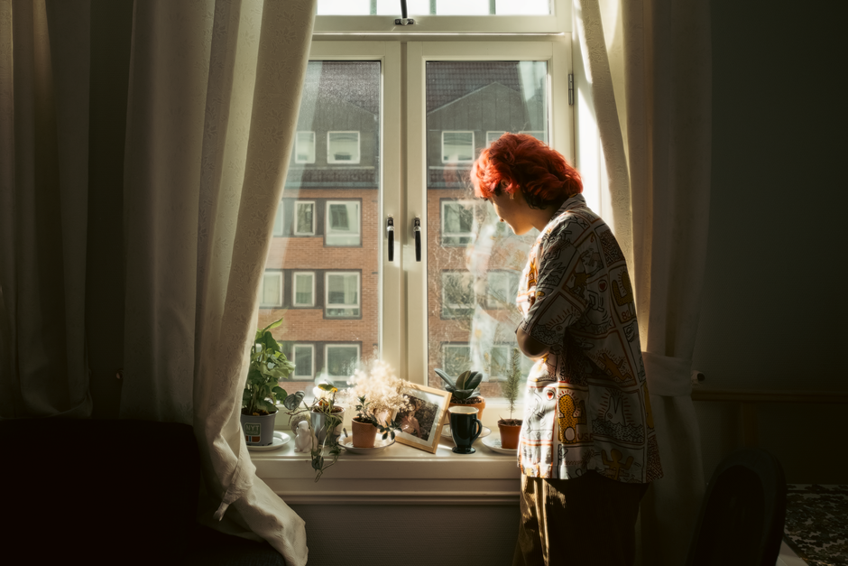 Light-colored curtains drawn across an apartment window to block the afternoon sun