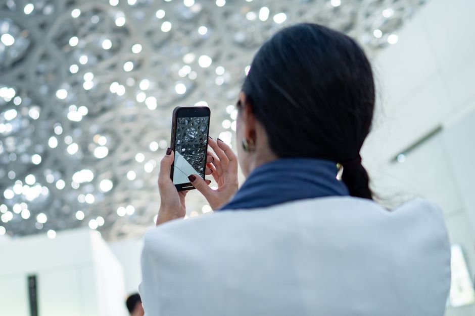 A person photographing water damage on a ceiling with a smartphone