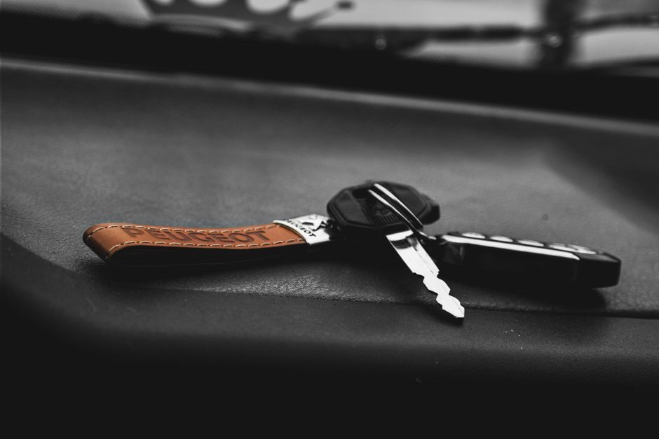 A unit door key and a building access fob resting on a wooden table
