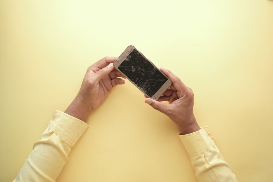 A tenant documenting water damage on a wall with a smartphone camera